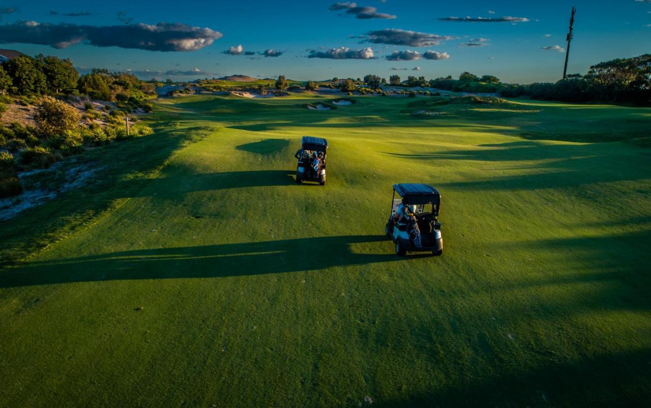 Pullman Magenta Shores Resort Entrance Kültér fotó Golf carts on the green